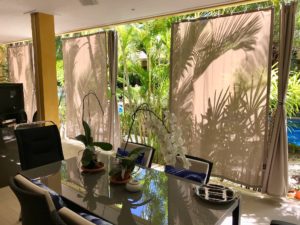 Halboffener Outdoor-Vorhang SANTORINI mit Blick nach Draussen. • rideaux123.ch