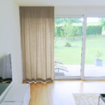 Nachtvorhang DENEB hellbraun in modernem Wohnzimmer. • rideaux123.ch
