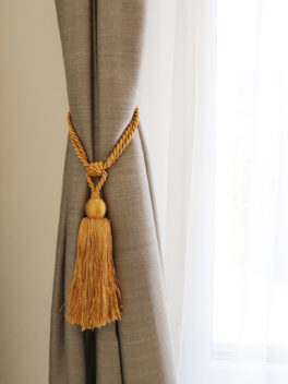 Raffhalter RHONE mit Quaste edles Gold an Vorhang befestigt
